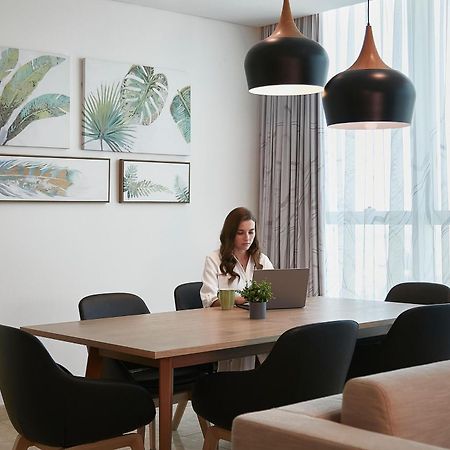 Element By Westin City Center Doha Bagian luar foto A woman working at home
