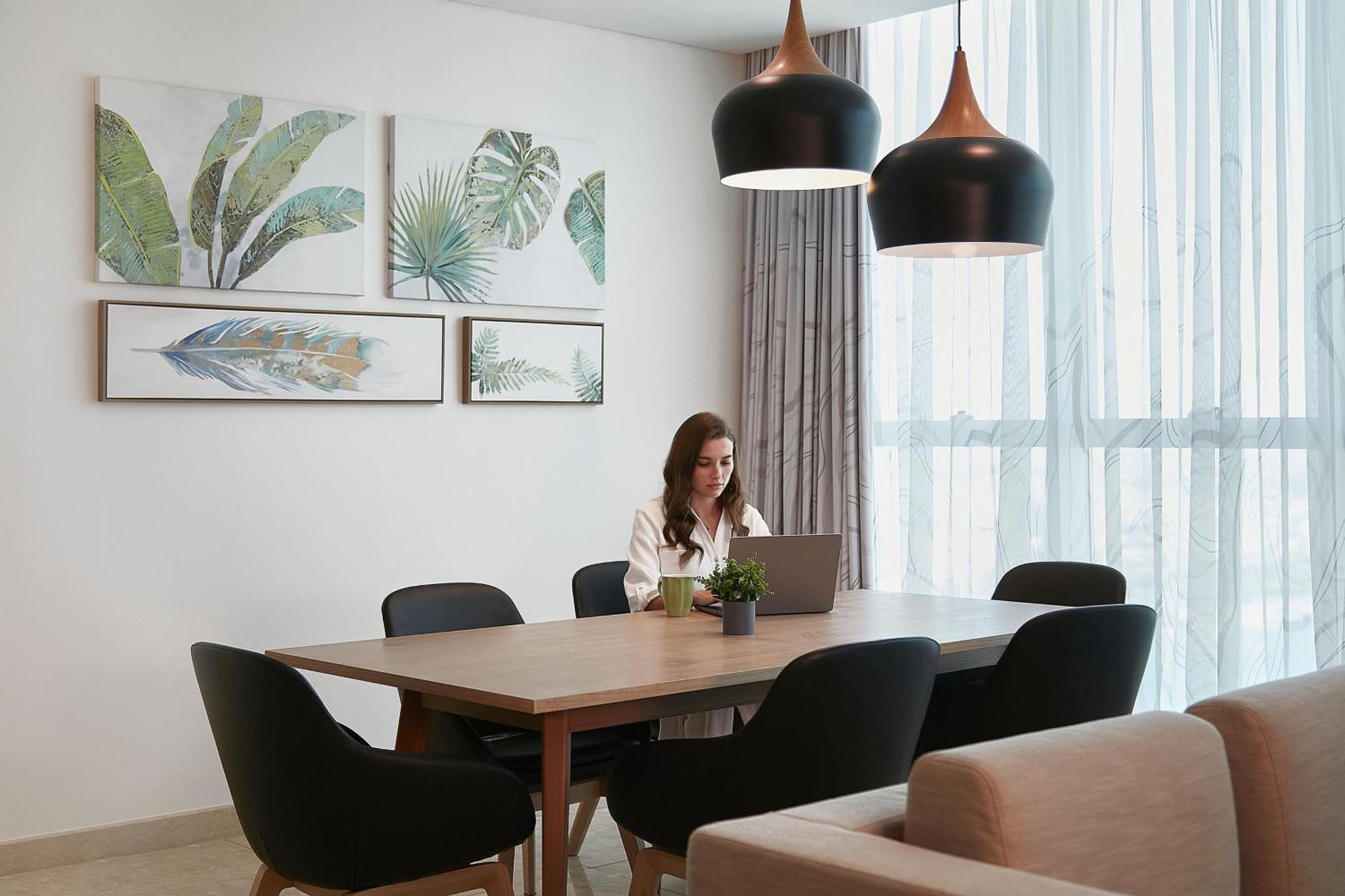 Element By Westin City Center Doha Bagian luar foto A woman working at home